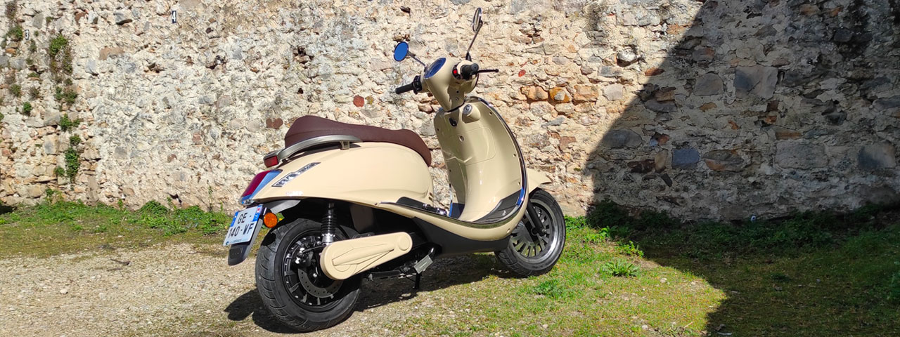 Rider 3000W beige devant un mur de vieille pierre