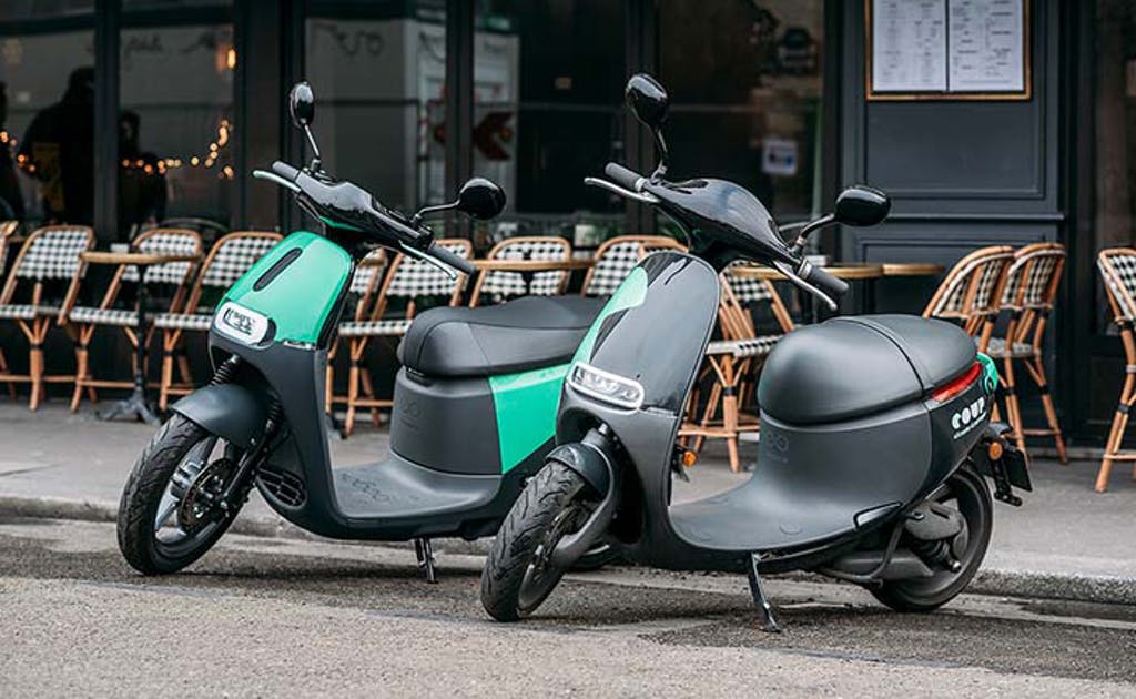 scooters de location COUP garés devant le trottoir