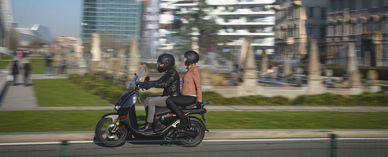 Couple sur Super Soco CPX dans les rues d'une grande ville