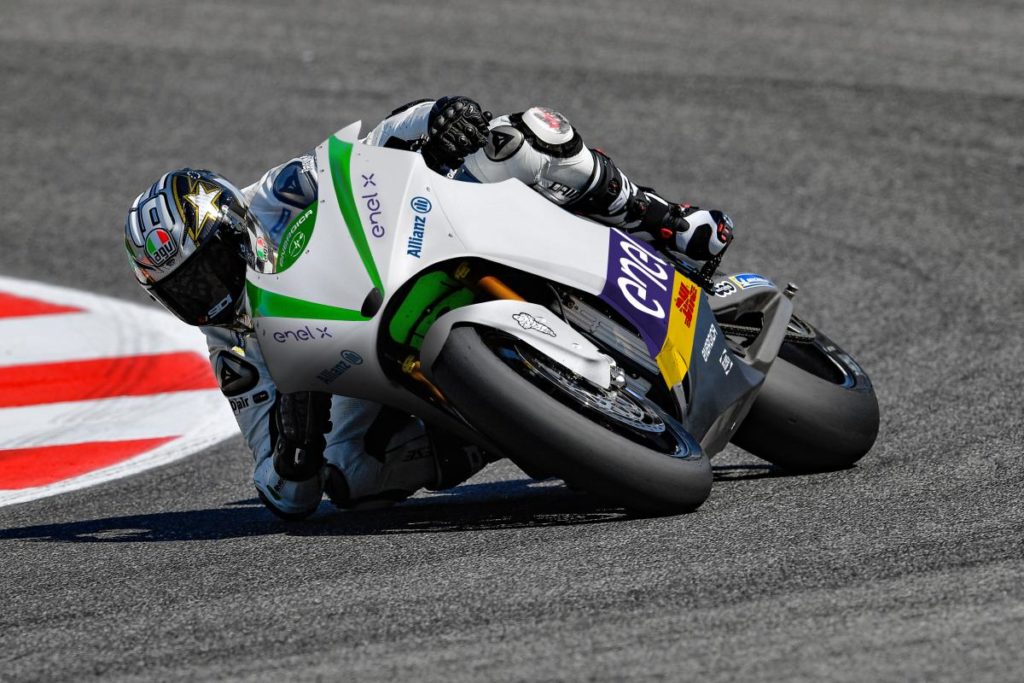 Pilote de MotoE en train de prendre un virage sur circuit.