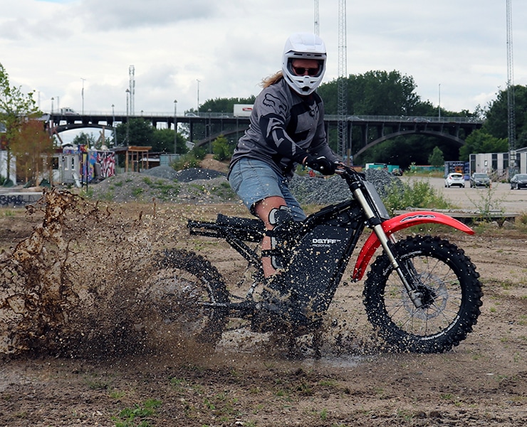 Moto de flat track sur un circuit en terre en train de faire patiner la roue arrière