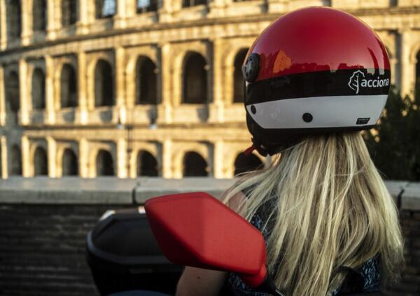 Utilisatrice d'un scooter électrique en libre service devant le Colisée à Rome.