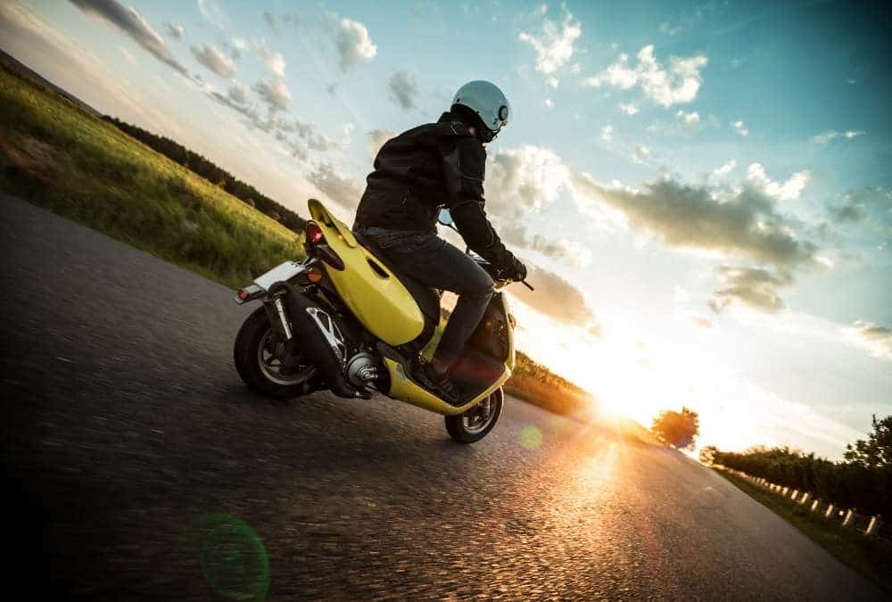 scooter jaune sur une route de campagne