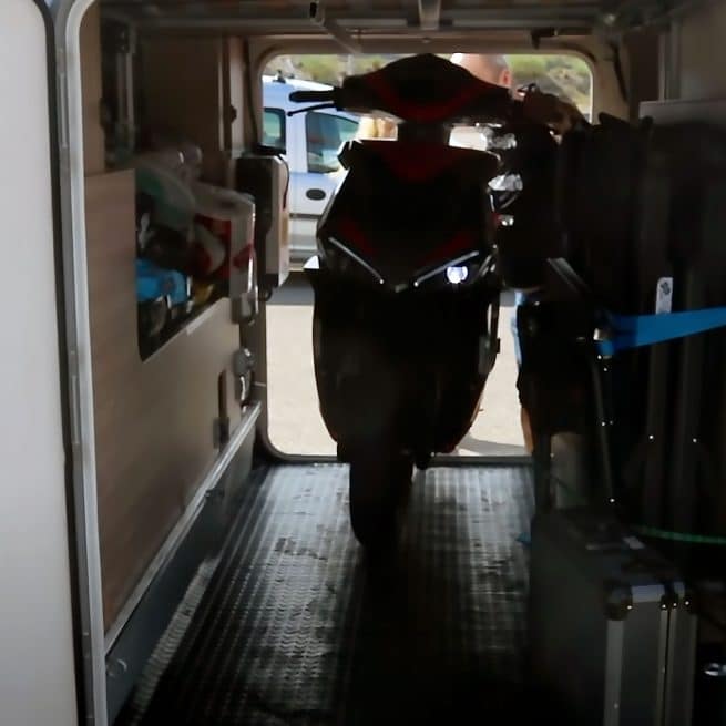 personnes en train d'installer l'ebroh strada li dans la soute d'un camping car