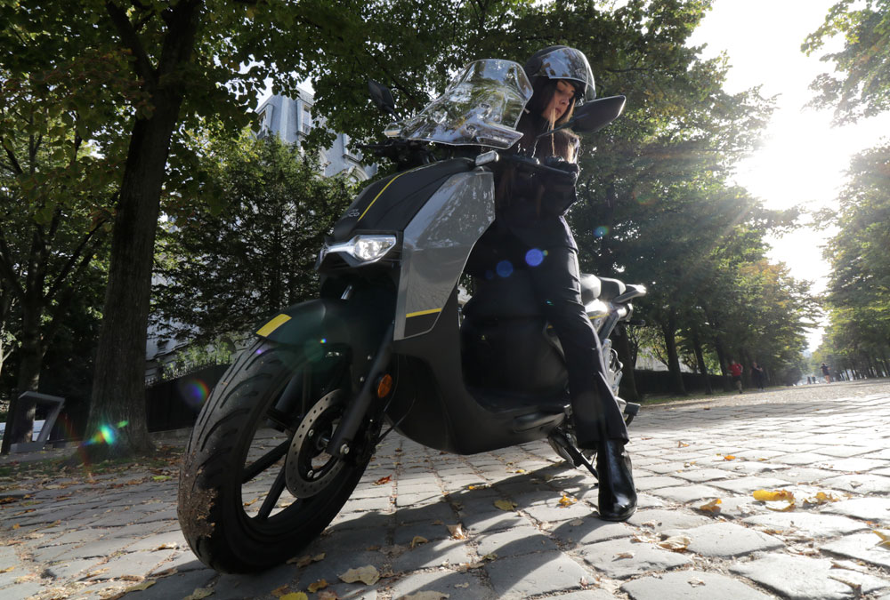 Le Super Soco CPX, scooter électrique 125, avec sa pilote dans un parc