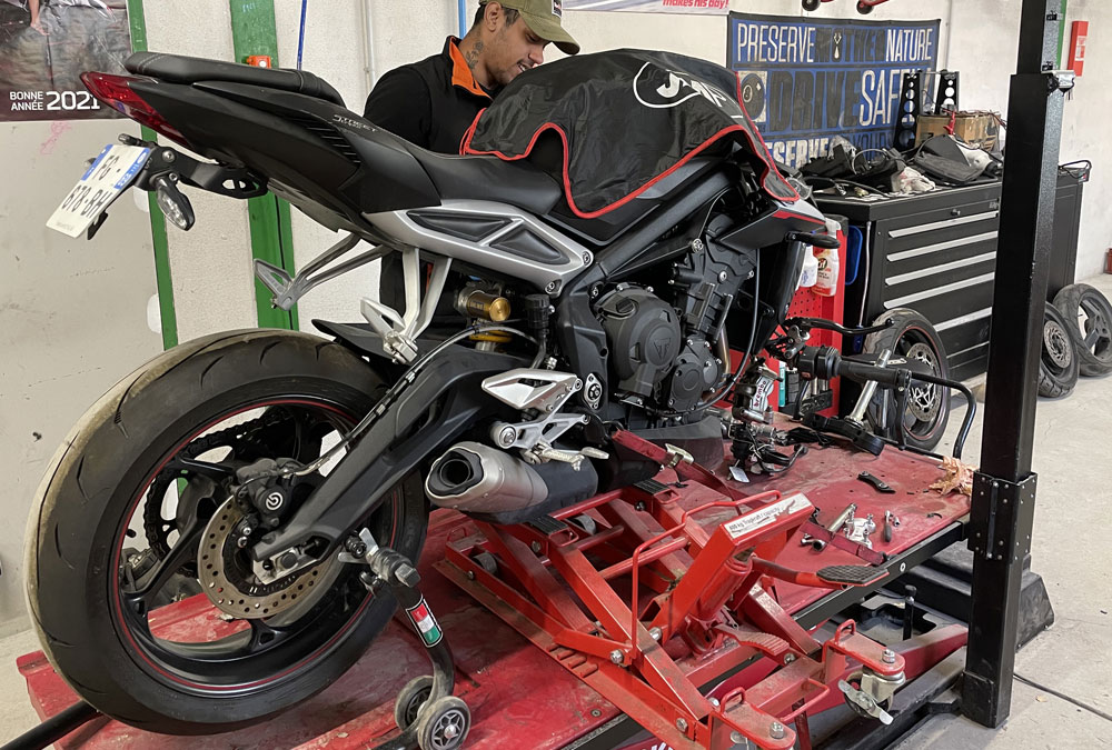 Une moto en train d'être réparée à la casse de l'Oncle Tom