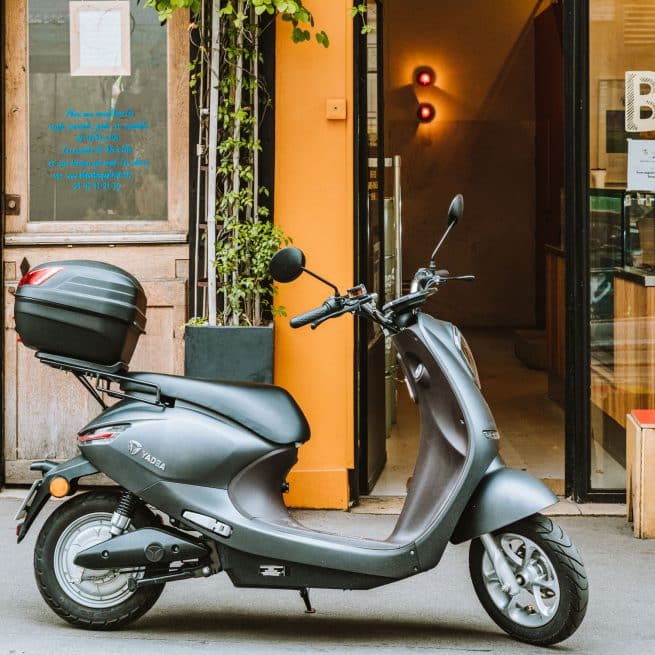 Un Yadea C-Umi noir avec son Top Case dans les rues de Paris