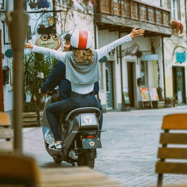 Couple sur un Yadea C Umi, de dos, dans les rues