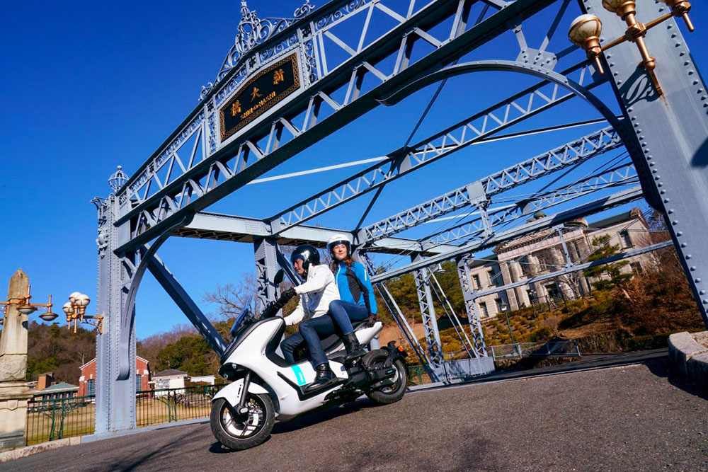 Le Yamaha E01 dans les rues d'une ville japonaise, sur un pont