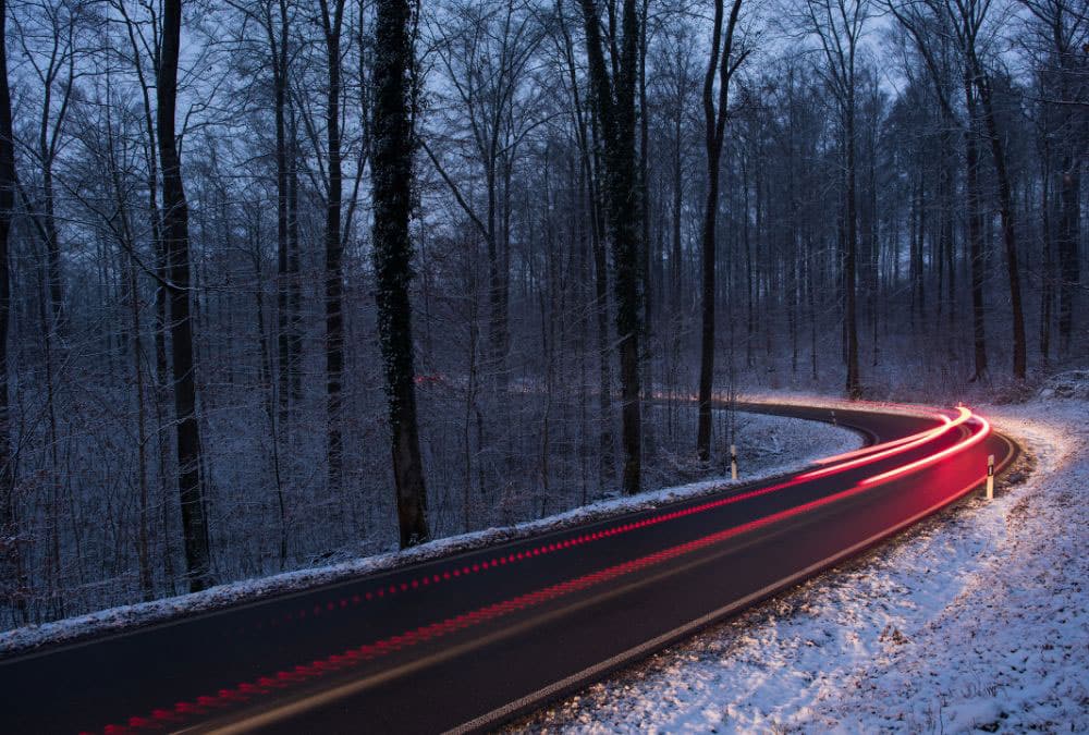 route de campagne l'hiver, avec les phares des scooters en timelapse