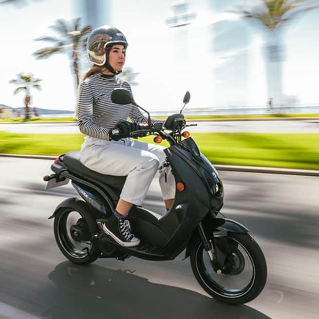 Jeune femme sur un Peugeot E-Ludix sur la promenade des Anglais