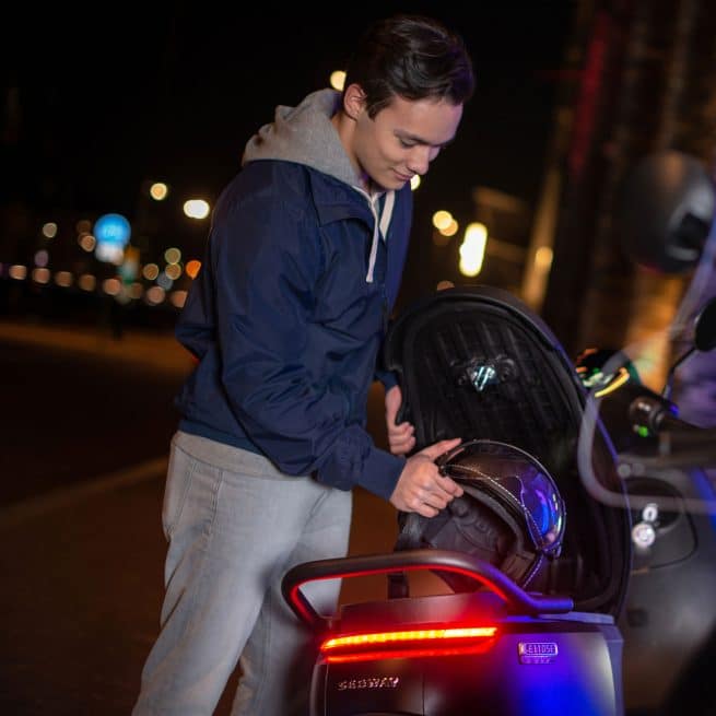 jeune homme rangeant son casque sous la selle du segway e110s