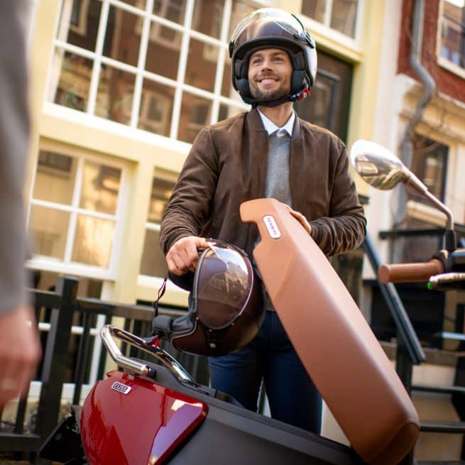 jeune homme en train d'installer un casque jet sous la selle de son segway e125s