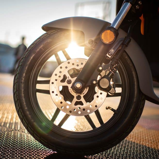 En gros plan, la roue avant du Segway B110s, avec le soleil en fond