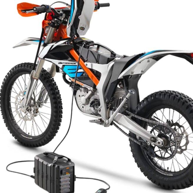 La KTM Freeride E-XC avec son chargeur, en train de charger