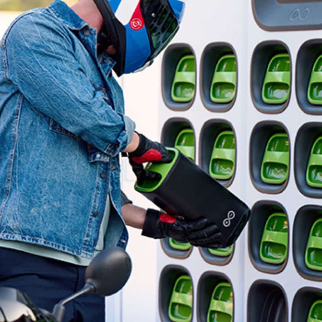 Un utilisateur insère une batterie dans une station d’échange Sweetch pour scooter électrique